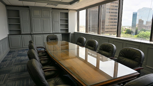 Boardroom with glass conference table and downtown skyline view